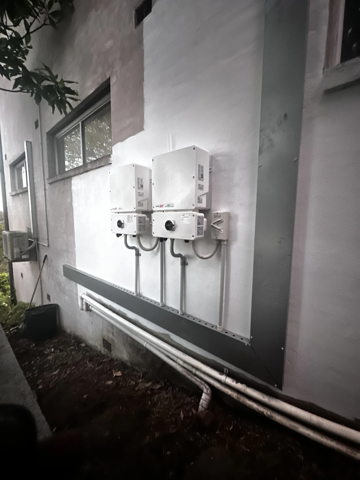 Three inverters neatly mounted in a row on an outside wall