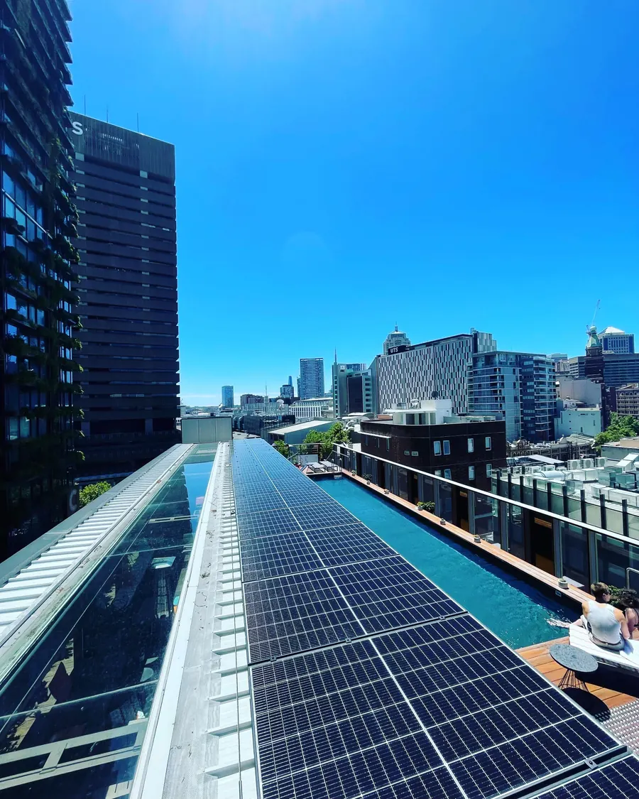 Commercial rooftop array beside a rooftop pool in the city
