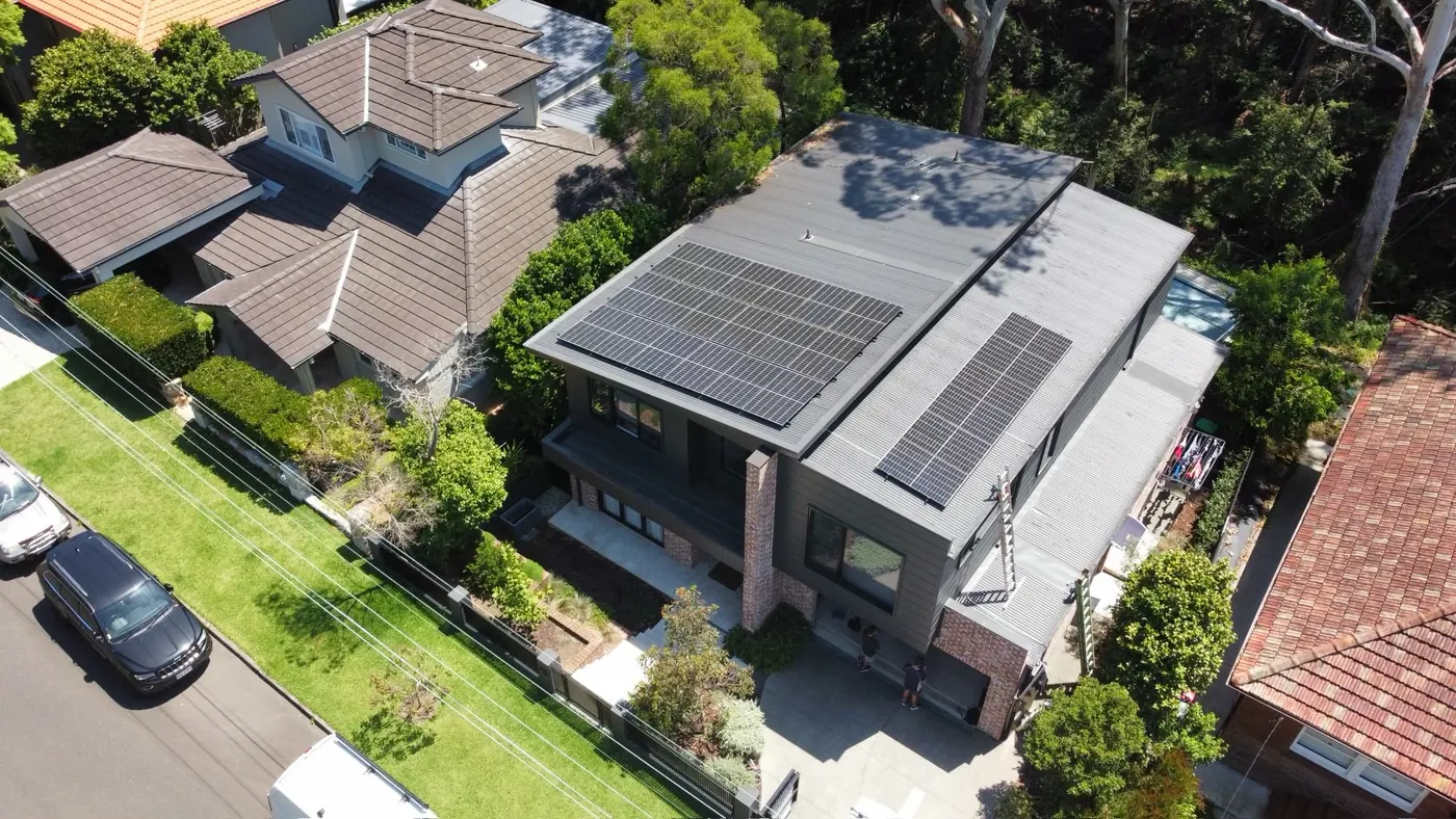 Black solar panels laid across a charcoal roof