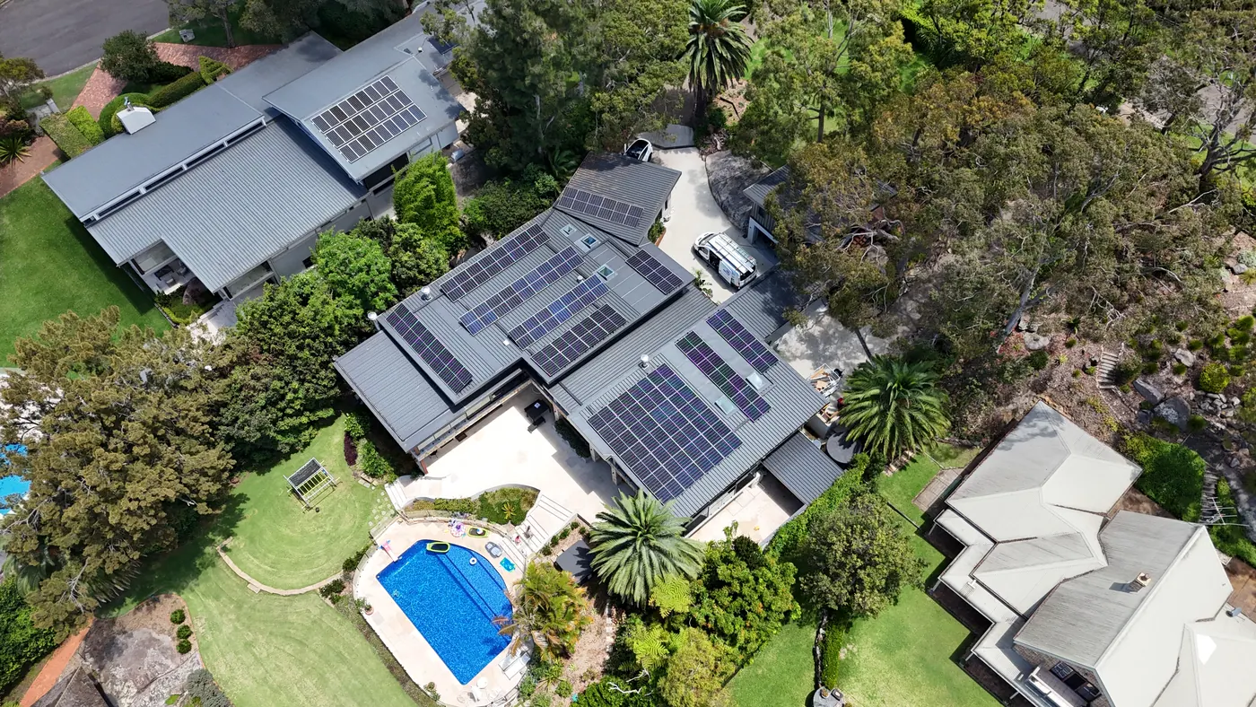 Solar array on a dark metal roof of a North Shore home with a pool